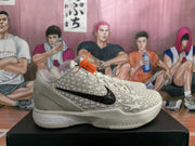 Side profile of an off-white Nike KD sneaker showing the black Swoosh, raised star pattern, textured toe area, and orange hangtag.