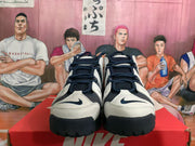 Front view of dark and light Nike high-top basketball sneakers with dark laces.