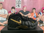 Side view highlighting the sculpted black upper, gold-colored Swoosh, and patterned panel.