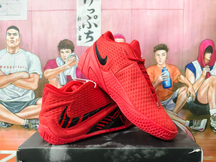 Red Nike basketball shoes with black Swoosh detailing, shown from the side and sole.