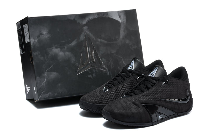 Pair of black Nike Metcon training shoes beside a black shoe box.