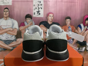 Rear view of white and black Nike basketball sneakers with padded collars and layered soles.