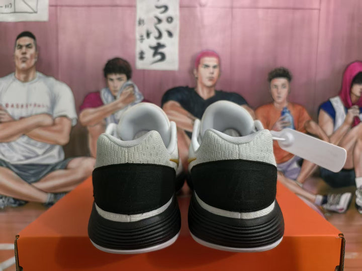 Rear view of white and black Nike basketball sneakers with padded collars and layered soles.