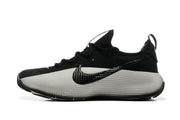 Side profile of a black and white training shoe with a textured side panel and logo.