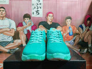 Front view of the turquoise sneakers showing the textured toe boxes, matching laces, and patterned outsoles.