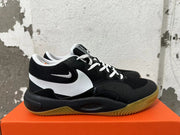 Side view of a black Nike sneaker with a white Swoosh and gum-colored outsole