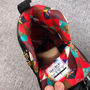 Close-up of the multicolor patterned lining, black laces, gold lace hardware, and interior size label.