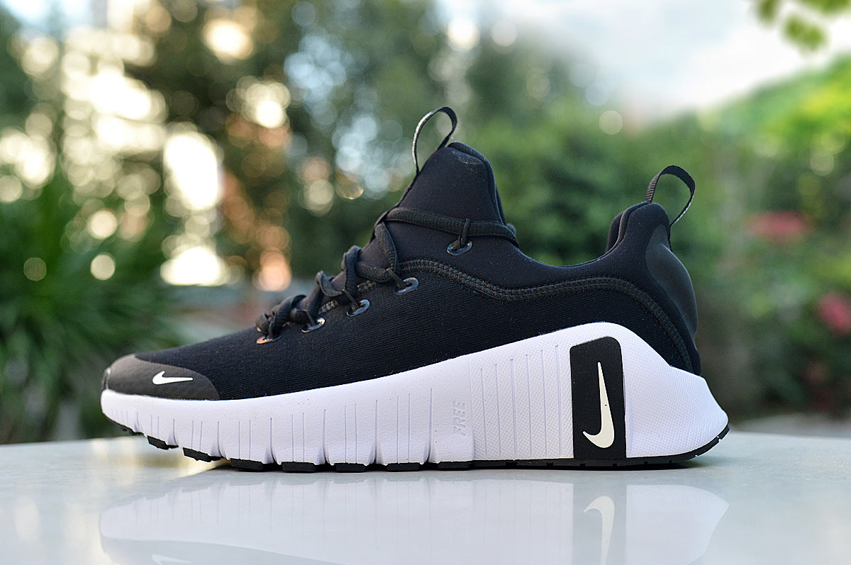 Side view of a black Nike low-top sneaker with a thick white sole and contrasting side logo.