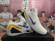 Angled view showing the white textured upper, purple Nike Swoosh, yellow side panel, and black side insert.