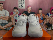Front view of white Nike basketball sneakers showing the lace-up design, tongue branding and textured toe areas.