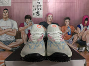 Front view of the sneaker pair showing white tongues, pink lace-area accents, blue patterned uppers, and black toe outsoles.
