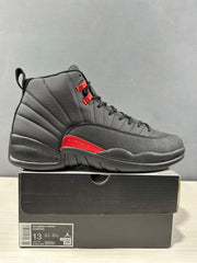 Side view of a black and red high-top sneaker with a visible box label showing Air Jordan 12 Retro and style code CT8013 003.