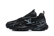 Side profile of a black sneaker with silver graphic overlays and a chunky outsole.
