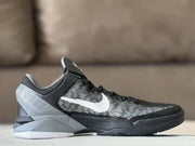 Side profile highlighting the black and grey upper, white Swoosh and angular midsole design.