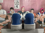 Rear view of white basketball shoes with blue heel details and light-colored soles