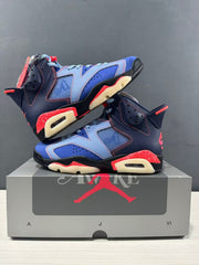 Angled product view showing both sneakers, layered panel construction, and contrasting red and cream sole sections.