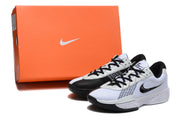 White and black Nike Academy sneakers pictured beside an orange Nike shoe box.