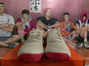 Front view of white Nike sneakers with light-colored laces, textured uppers, and red toe and outsole accents.