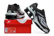 Nike Shox Ride 2 sneakers in brown, silver, and black beside a red Nike box; the box label shows a sample size.