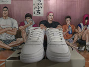 Front view of the white sneakers showing white laces, perforated toe panels, and low-top construction.