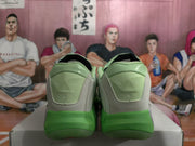 Rear view showing the padded green-and-gray heel panels and green outsole sections.