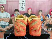 Rear view of the orange Nike sneakers showing the textured heel panels and translucent orange outsoles.