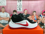 Side profile of a black and white high-top sneaker with a red Nike swoosh-style detail and red outsole.