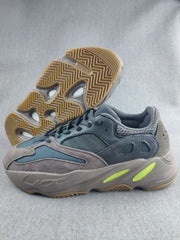 Side view of the gray and blue 700 sneaker showing the layered upper, sculpted sole, and gum-colored outsole.