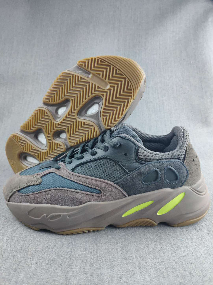 Side view of the gray and blue 700 sneaker showing the layered upper, sculpted sole, and gum-colored outsole.