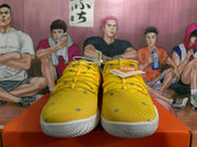 Front view of yellow Nike basketball sneakers with yellow laces, grey accents, and white outsoles.