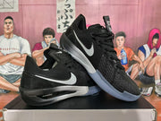 Angled view of a pair of black Nike basketball sneakers with white Swoosh branding and blue translucent outsoles.