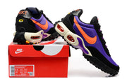 Purple, orange, and black Nike Air Max Plus Utility sneakers shown with a red shoe box.