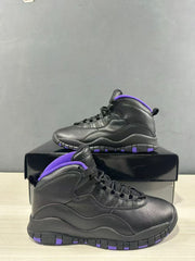 Angled view of the black high-top sneakers showing the textured upper, laces, and purple accents.