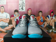 Front view of gray Nike Kobe basketball shoes with black, blue, and red accents