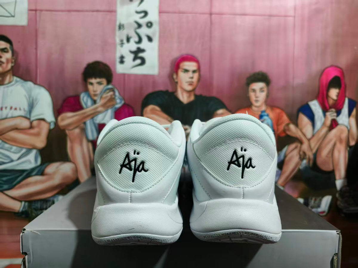 Rear view of white Nike A'ja sneakers showing A'ja heel lettering and black outsole accents.