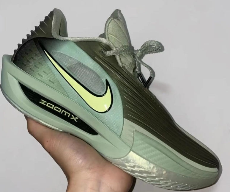 Green Nike sneaker shown from the lateral side, with a light Swoosh, lace-up upper, sculpted sole, and visible ZoomX branding.