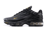 Side profile of a black Nike Air Max Plus III sneaker with gold Swoosh and visible sole cushioning.