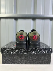 Rear view of the pair showing green collars, brown heel panels, red circular heel details, and black midsoles.
