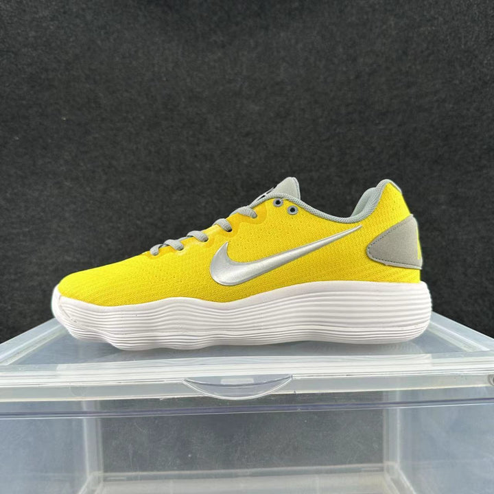 Side view of a yellow Nike low-top sneaker with gray accents, gray laces, a silver-tone Swoosh, and a white ridged sole.