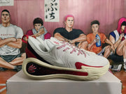 Side view of a white Kai basketball shoe with red accents and a sculpted cream-colored sole.