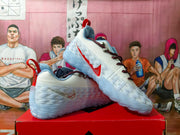 Pair of white Nike basketball sneakers with red accents displayed on a red shoebox.