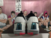 Rear view of white and pink Nike basketball sneakers positioned on a shoebox.