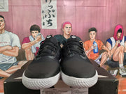 Front view of black low-top sneakers with black laces and white textured outsoles.
