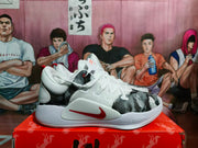 Side view of a white Nike basketball sneaker showing the gray patterned upper panel, red side branding, and textured outsole.