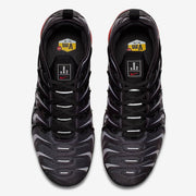 Top-down view of a pair of black and gray patterned Nike Air VaporMax Plus sneakers.