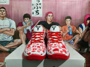 Front view of the red and white basketball sneakers with red laces, patterned toe boxes, and basketball-player emblems on the tongues.