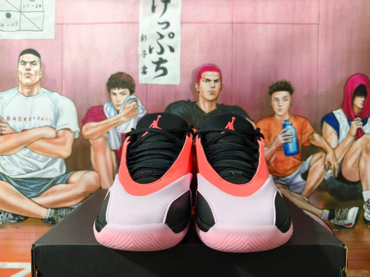 Front view of pink, black, and white Jordan basketball sneakers displayed on a box.