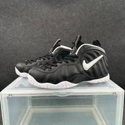 Three-quarter view of a pair of black Nike high-top sneakers with white Swooshes, black laces and white outsoles.