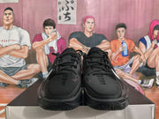 Front view of black Nike basketball sneakers with black laces, padded tongues, and subtle white Swoosh details.
