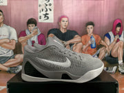 Side profile of a grey knit-look basketball shoe with white Swoosh detailing